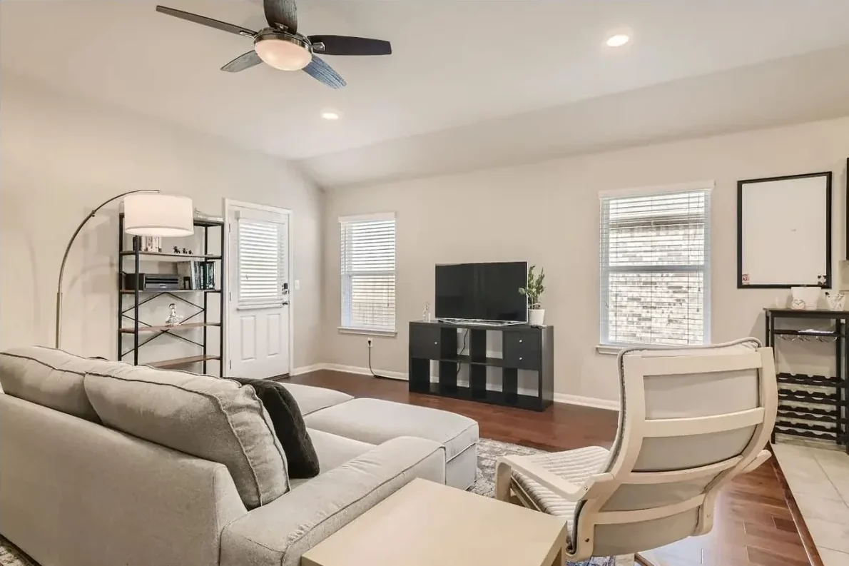 Austin living room with a pale sectional, ceiling fan, television and shuttered windows